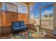 Enclosed sunroom with large windows, comfortable seating, and bright, patterned rug at 19802 N Greenview Dr, Sun City West, AZ 85375