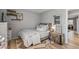 A cozy bedroom featuring wood-look flooring, a decorative mirror, and warm accent lighting at 19930 N 98Th Ave, Peoria, AZ 85382