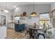 Open dining area featuring an island, pendant lighting, and luxury vinyl plank flooring at 19930 N 98Th Ave, Peoria, AZ 85382