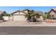 Exterior shot showcasing the tan home's facade, two-car garage, and desert landscaping at 19930 N 98Th Ave, Peoria, AZ 85382