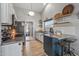 Galley kitchen featuring stainless steel appliances, open shelving and kitchen island at 19930 N 98Th Ave, Peoria, AZ 85382