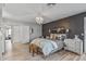 This is the main bedroom, featuring a decorative chandelier, dark accent wall, and a view of the backyard at 19930 N 98Th Ave, Peoria, AZ 85382