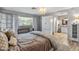 A cozy main bedroom with a decorative chandelier, wood floors, and a view of the main bath at 19930 N 98Th Ave, Peoria, AZ 85382