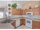 Kitchen featuring white appliances, wooden cabinets, and tile flooring at 221 N 151St Ave, Goodyear, AZ 85338