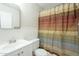 Modest bathroom with colorful striped shower curtain, vinyl walls and flooring at 2338 W Lupine Ave, Phoenix, AZ 85029