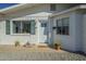 Close-up of the front entrance, showcasing the updated windows, potted plants, and welcome mat at 2338 W Lupine Ave, Phoenix, AZ 85029