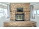 Living room fireplace featuring a brick surround, wood mantel and a mounted television at 2338 W Lupine Ave, Phoenix, AZ 85029