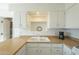 Close-up of the kitchen sink area, showcasing the bright cabinets, butcher block countertops, and modern fixtures at 2338 W Lupine Ave, Phoenix, AZ 85029