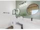 Stylish bathroom features dual sinks, modern fixtures, and a decorative green shiplap accent wall at 23407 W Ashleigh Marie Dr, Buckeye, AZ 85326