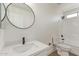 A modern bathroom with a circular mirror and a shower with white tiling at 23407 W Ashleigh Marie Dr, Buckeye, AZ 85326