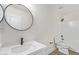 A modern bathroom with a circular mirror and a shower with white tiling at 23407 W Ashleigh Marie Dr, Buckeye, AZ 85326