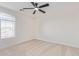 A bedroom with natural light, a ceiling fan, and a large window at 23407 W Ashleigh Marie Dr, Buckeye, AZ 85326