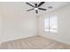 A cozy bedroom with neutral tones, ceiling fan, and a window at 23407 W Ashleigh Marie Dr, Buckeye, AZ 85326