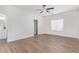 Bright bedroom with wood-look flooring, a ceiling fan, and ensuite bathroom access at 23407 W Ashleigh Marie Dr, Buckeye, AZ 85326