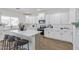 Modern kitchen featuring white cabinetry, stainless steel appliances, and a large center island with seating at 23407 W Ashleigh Marie Dr, Buckeye, AZ 85326