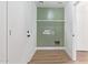 Functional laundry room with wood-look floors and green accent wall at 23407 W Ashleigh Marie Dr, Buckeye, AZ 85326