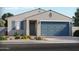 Charming single-story home showcasing a two-car garage, gray stucco, blue door, shutters, and desert landscaping at 24383 W La Salle St, Buckeye, AZ 85326