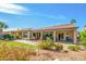 Spacious backyard with a covered patio, lush lawn, desert landscaping and view of the home's facade at 24413 S Lakeway Sw Cir, Sun Lakes, AZ 85248