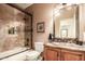 Detailed bathroom featuring a granite vanity top and glass enclosed shower-tub combination at 24413 S Lakeway Sw Cir, Sun Lakes, AZ 85248