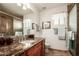 Bathroom features a beautiful vanity with granite countertops, decorative mirror, and a tiled shower at 24413 S Lakeway Sw Cir, Sun Lakes, AZ 85248