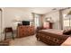 Relaxing bedroom with warm wood furniture, natural light, and neutral carpeting at 24413 S Lakeway Sw Cir, Sun Lakes, AZ 85248