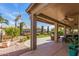 View of a covered patio that looks out to a landscaped yard with lush garden and manicured lawn at 24413 S Lakeway Sw Cir, Sun Lakes, AZ 85248