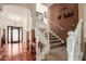 Inviting foyer with hardwood floors, staircase, and decorative iron door, welcoming guests into this stylish home at 24413 S Lakeway Sw Cir, Sun Lakes, AZ 85248