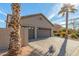 Three-car garage with brick driveway, accented with desert landscaping and palm trees at 24413 S Lakeway Sw Cir, Sun Lakes, AZ 85248