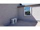 Exterior shot showcasing the home's gray stucco finish, a window, and an AC unit at 246 E Central Ave, Coolidge, AZ 85128