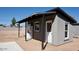 Exterior shot showcasing the home with gray stucco finish, a door, and appliances at 246 E Central Ave, Coolidge, AZ 85128