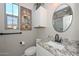 Stylish bathroom featuring granite countertops, a modern sink, and a decorative round mirror at 27709 N 129Th Ln, Peoria, AZ 85383