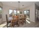 Bright dining room with modern lighting, wooden table set, and views of the backyard at 27709 N 129Th Ln, Peoria, AZ 85383