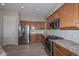 Well-lit kitchen features stainless steel appliances, granite countertops, and wood cabinets at 27709 N 129Th Ln, Peoria, AZ 85383