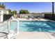 A pristine community pool features a wheelchair access lift, lounge chairs, and palm trees at 2777 W Queen Creek Rd # 13, Chandler, AZ 85248