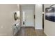 Bright foyer with light wood floors, a mirrored console table, and a view of the front door at 2777 W Queen Creek Rd # 13, Chandler, AZ 85248