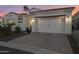 Exterior view of stucco home with a tile roof and brick driveway at dusk at 2777 W Queen Creek Rd # 13, Chandler, AZ 85248