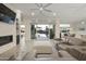 Bright living room with water views from sliding glass doors, modern ceiling fan, and gray leather furniture at 2777 W Queen Creek Rd # 13, Chandler, AZ 85248