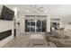 Open-concept living room with fireplace, tile floors, and waterfront views from the sliding glass doors at 2777 W Queen Creek Rd # 13, Chandler, AZ 85248