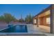 View of backyard pool with rock waterfall feature and desert landscaping, patio and home at 29399 N 67Th Way, Scottsdale, AZ 85266