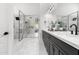 This bathroom offers double sinks, marble countertops, black cabinetry, and a glass door shower at 29399 N 67Th Way, Scottsdale, AZ 85266