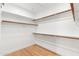 Bright walk-in closet with wooden rods and white shelving to maximize storage space at 29399 N 67Th Way, Scottsdale, AZ 85266