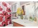 Bright bathroom featuring a decorative shower curtain, vanity with an artistic floral design, and ample counter space at 29576 N Gecko Trl, San Tan Valley, AZ 85143