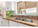 Kitchen sink with granite countertop, white cabinetry, and stainless steel faucet under a window at 29576 N Gecko Trl, San Tan Valley, AZ 85143