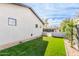 Well-maintained backyard with lush artificial turf, contemporary wall design, and privacy landscaping at 3033 E Roma Ave, Phoenix, AZ 85016