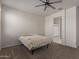 Carpeted bedroom with neutral walls, ceiling fan and ensuite bathroom access at 30940 W Indianola Ave, Buckeye, AZ 85396