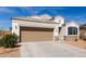 Attractive single-story home featuring a two-car garage, desert landscaping, and stone veneer accents at 30940 W Indianola Ave, Buckeye, AZ 85396