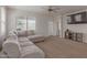 Bright living room with a large sectional sofa, neutral carpet, and a window with natural light at 30940 W Indianola Ave, Buckeye, AZ 85396