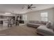 Open-concept living area connecting to the kitchen, featuring a sectional sofa, ceiling fan, and ample seating at 30940 W Indianola Ave, Buckeye, AZ 85396