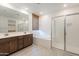 Bright bathroom featuring a soaking tub, double vanity, and glass-enclosed shower at 34074 N Beeblossom Trl, San Tan Valley, AZ 85144