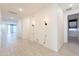 Hallway features tile floors and modern sconces with a view of the living and dining rooms at 34074 N Beeblossom Trl, San Tan Valley, AZ 85144